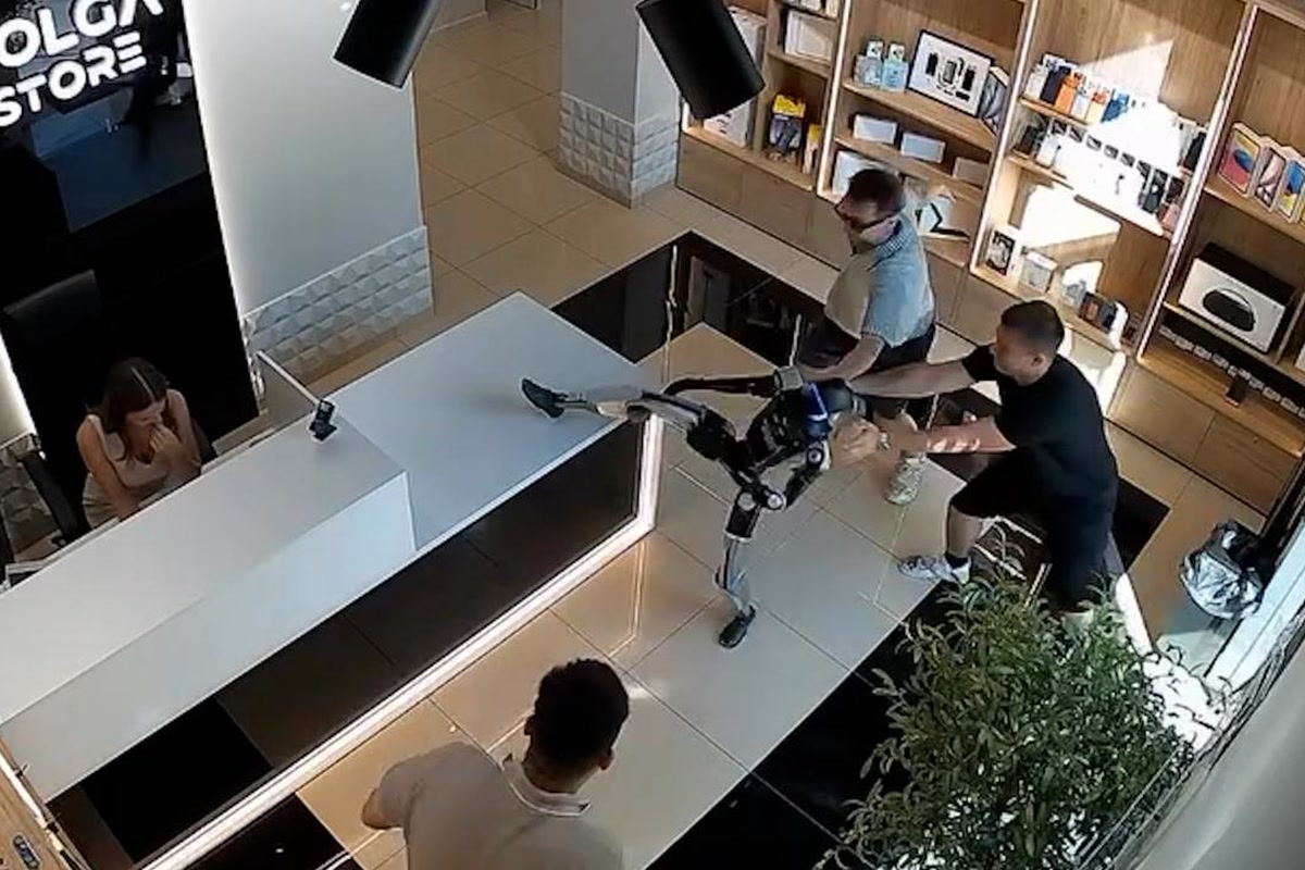 工作人员上前控制门店内的人形机器人